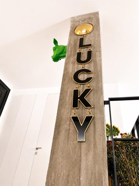 LUCKY wall pendant by Tali Veinrib, enamel letters framed in polished brass, view 2
